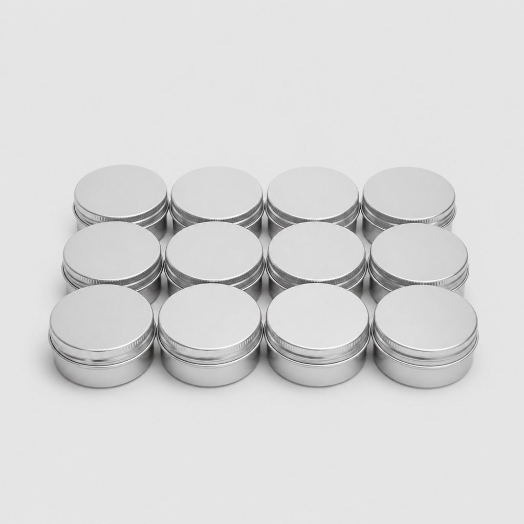 Douze petits pots en aluminium posés côte à côte sur fond clair