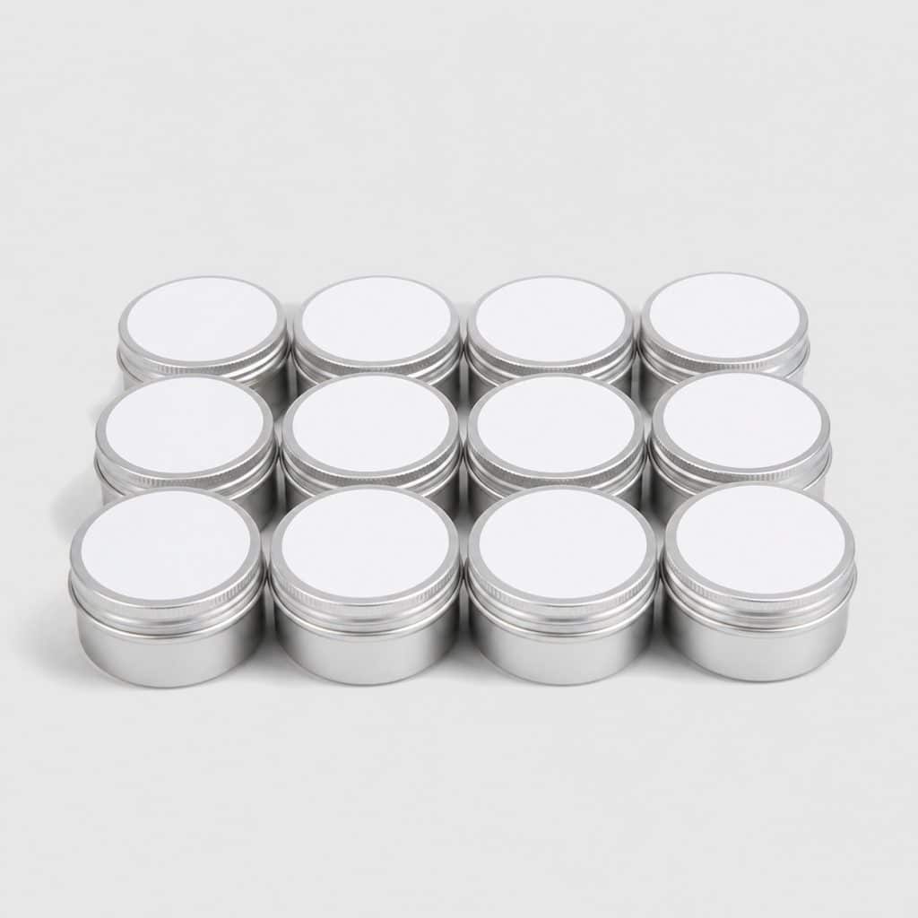 Douze pots en aluminium avec étiquettes vierges collées sur le couvercle