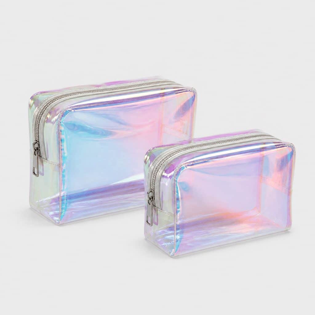 Deux petites trousses transparentes à reflet irisé posées sur fond clair
