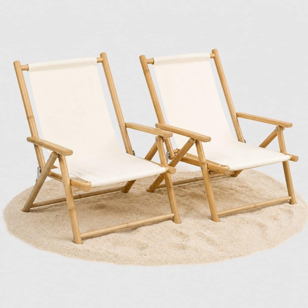 Deux chaises de camping pliantes en bambou et toile posées sur le sable