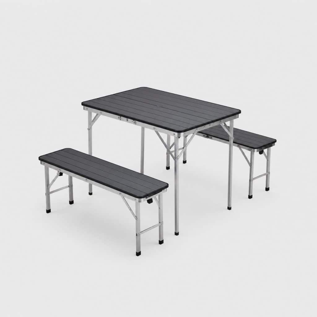 Table de camping pliable avec deux bancs assortis sur une pelouse